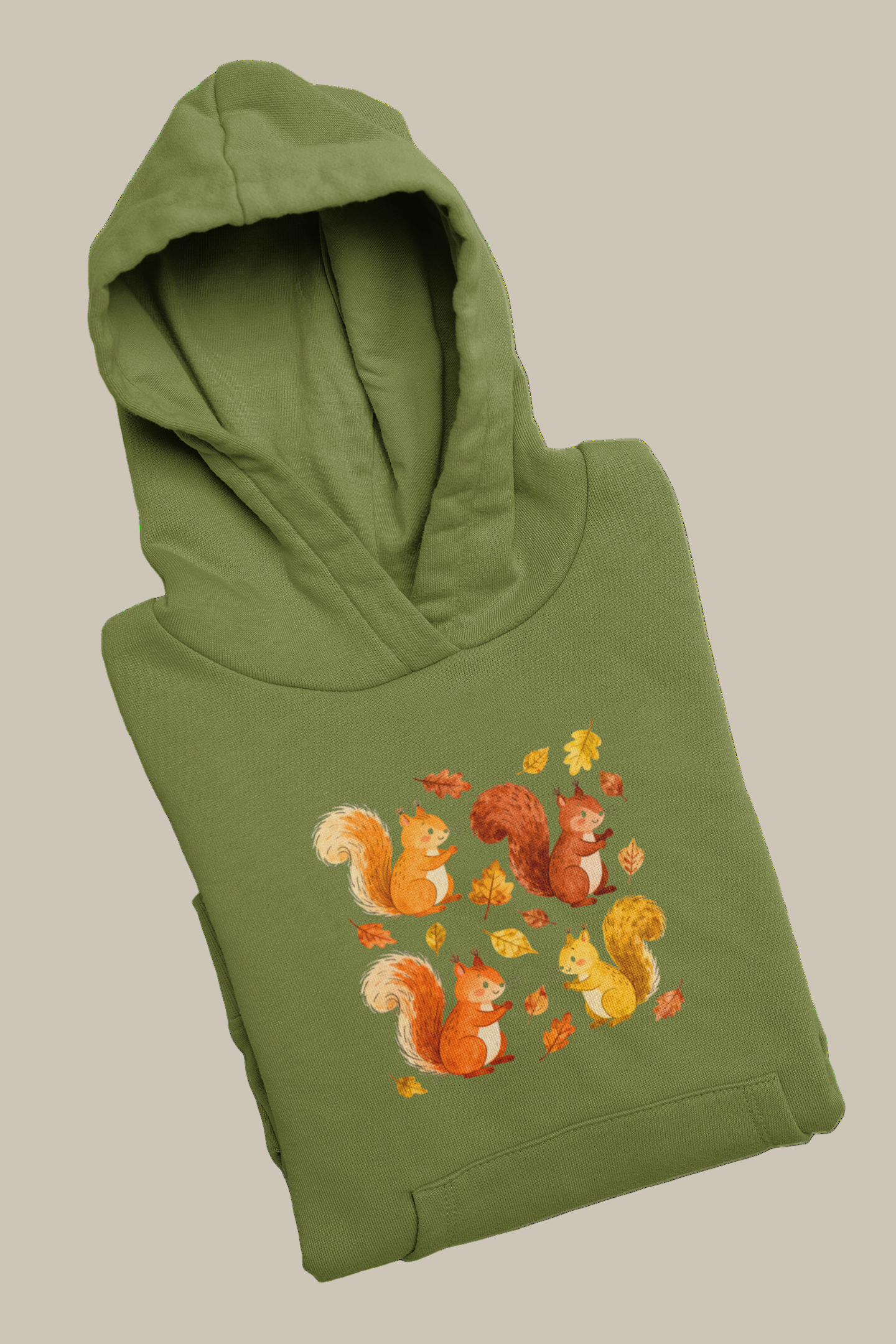 Folded green hoodie with autumn-themed design of squirrels and leaves on a beige background